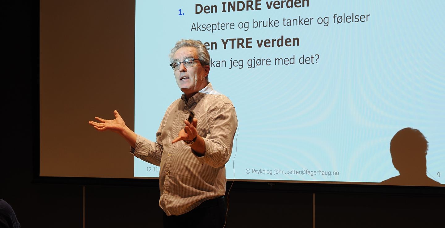 John Petter Fagerhaug på scenen foran et lysbilde om den indre og den ytre verden